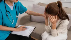A sad woman being consoled by a doctor.