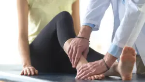 A woman with a sprained ankle getting checked out by a doctor. 